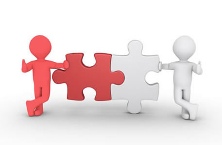 two human figures leaning on interlocking puzzle pieces